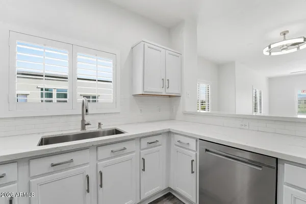 a kitchen with stainless steel appliances white cabinets and a window