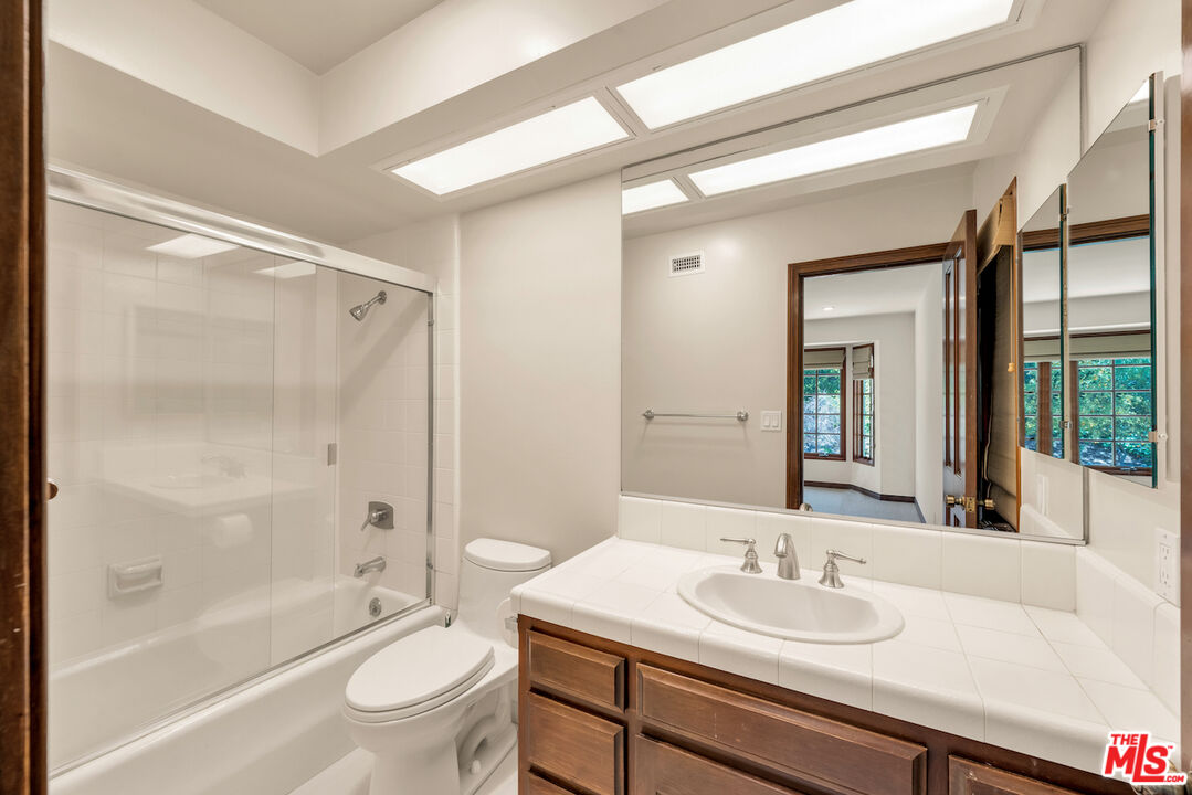 3274 Hutton Drive Beverly Hills, CA 90210 - Photo 19 of 23 a bathroom with a sink a toilet and a large mirror