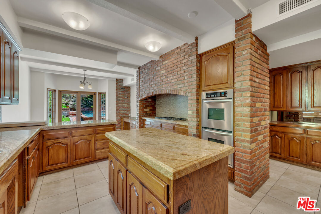 3274 Hutton Drive Beverly Hills, CA 90210 - Photo 3 of 23 a kitchen with a stove a sink and a refrigerator