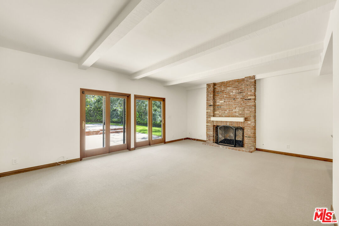 3274 Hutton Drive Beverly Hills, CA 90210 - Photo 8 of 23 an empty room with furniture and a fireplace