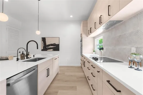a large white kitchen with a double vanity sink and a large window