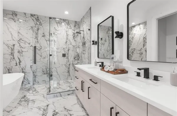 a bathroom with a double vanity sink toilet mirror and shower