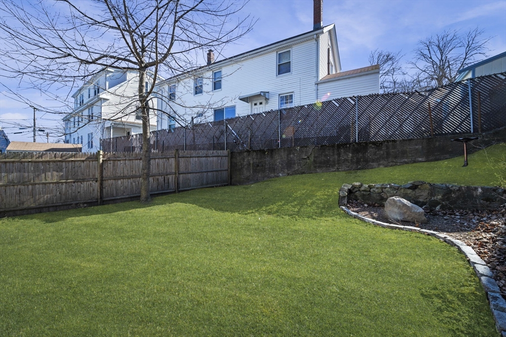 10 Stoddard Terrace Lynn, MA 01902 - Photo 33 of 40 a view of a backyard with large trees and wooden fence