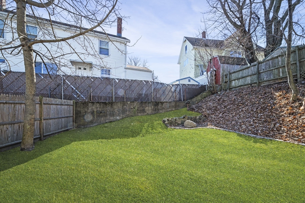 10 Stoddard Terrace Lynn, MA 01902 - Photo 34 of 40 a view of a backyard with plants and a wooden fence