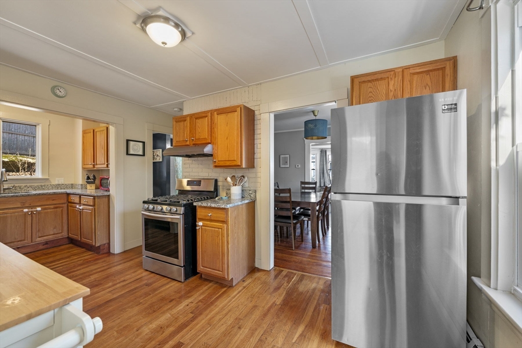 10 Stoddard Terrace Lynn, MA 01902 - Photo 5 of 40 a kitchen with granite countertop stainless steel appliances a refrigerator cabinets and wooden floor