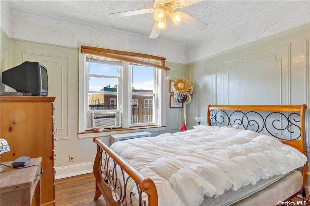a bedroom with a bed and a flat tv screen on dresser