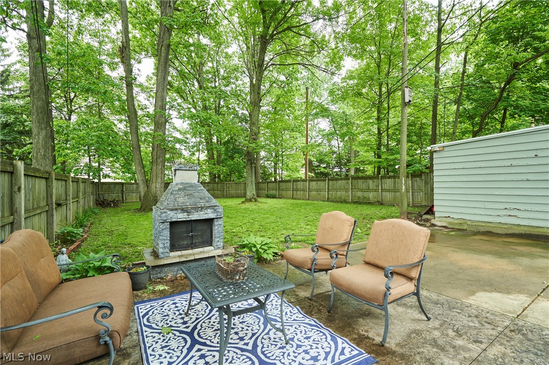 4531 Ardendale Road Cleveland, OH 44121 - Photo 23 of 25 Fenced backyard featuring a patio area and an outdoor living space with a fireplace