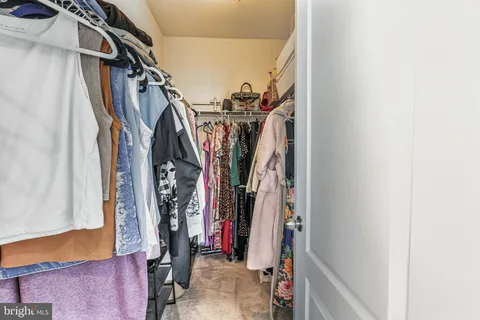 a view of walk in closet with clothes