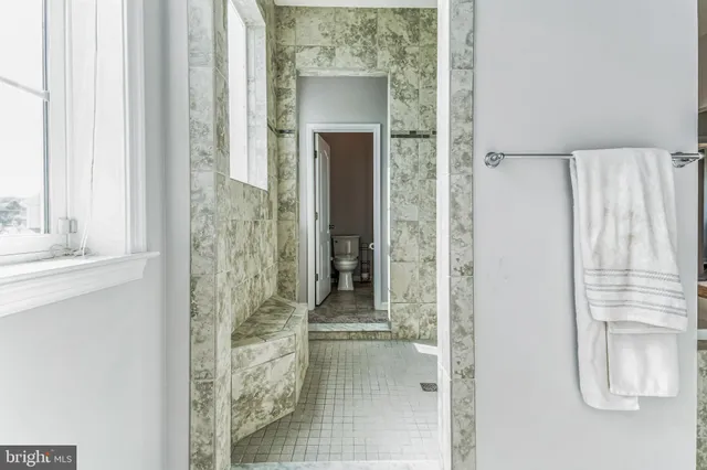 a bathroom with a glass shower door and a window