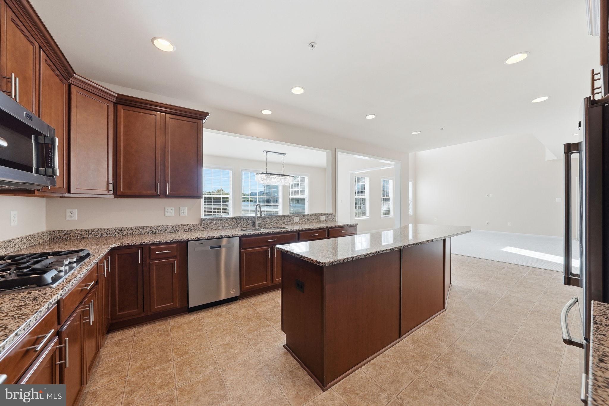 11538 Neon Road Fort Washington, MD 20744 - Photo 10 of 58 a large kitchen with stainless steel appliances granite countertop a stove a sink dishwasher and a refrigerator with wooden cabinets