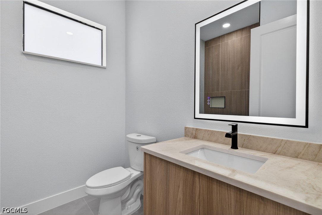 1715 Southwest 4th Street Cape Coral, FL 33991 - Photo 29 of 42 a bathroom with a toilet sink and mirror