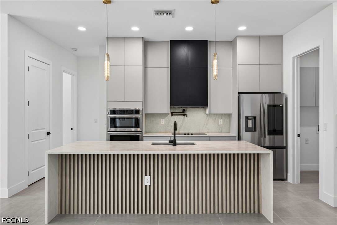 1715 Southwest 4th Street Cape Coral, FL 33991 - Photo 8 of 42 a kitchen with stainless steel appliances granite countertop a refrigerator a sink and a refrigerator