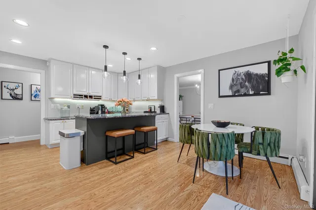 a room with stainless steel appliances kitchen island granite countertop furniture and a dining table