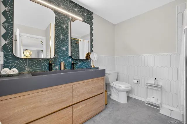 a bathroom with a sink a toilet and mirror