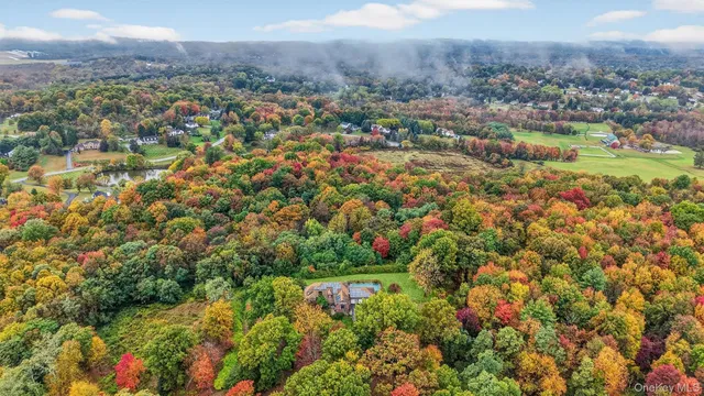 an aerial view of residential house with outdoor space and trees all around