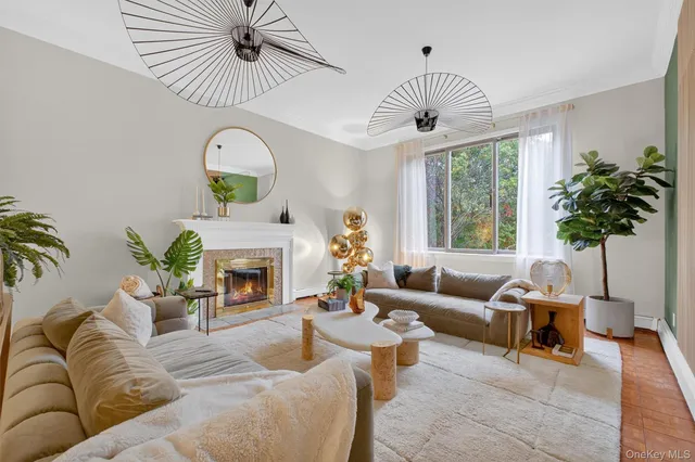 a living room with furniture a fireplace and a chandelier