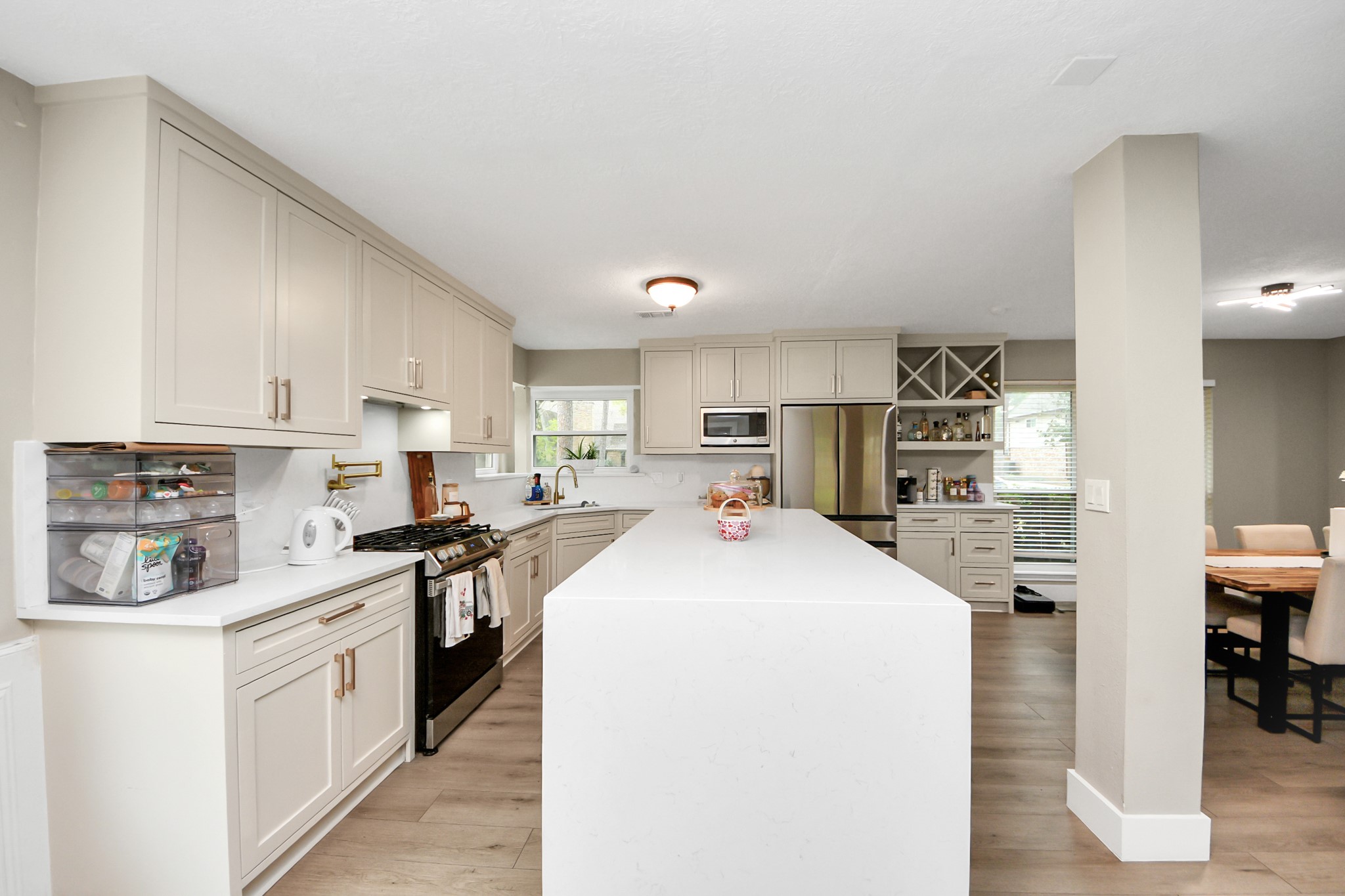 5511 Lacreek Lane Spring, TX 77379 - Photo 16 of 39 a kitchen with stainless steel appliances a stove a sink a refrigerator a stove and white cabinets with wooden floor