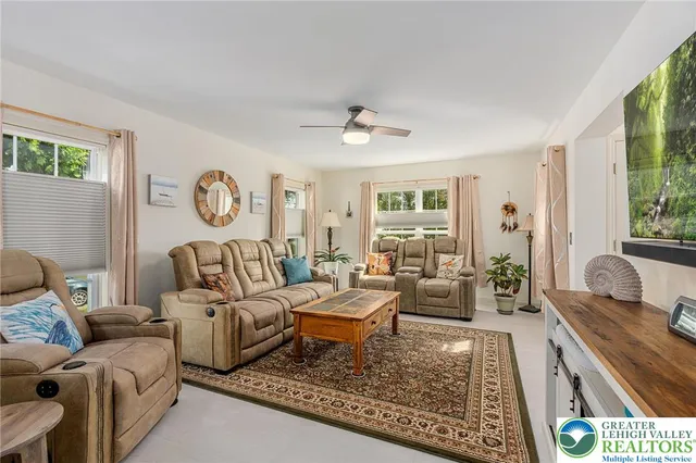 a living room with furniture a rug and a large window