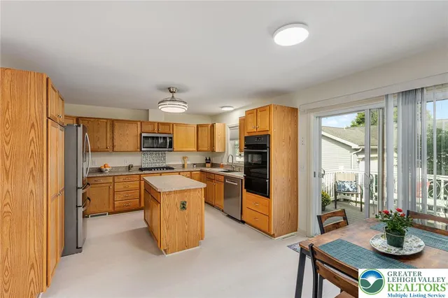a kitchen with a stove a refrigerator and a dining table with wooden floor