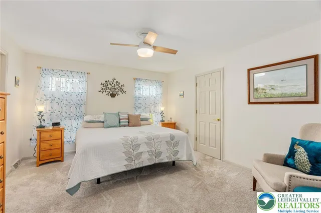 a bedroom with a bed a dresser and a flat screen tv