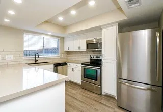 a kitchen with stainless steel appliances a refrigerator sink and microwave