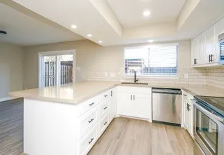 a view of a kitchen with a sink and a refrigerator
