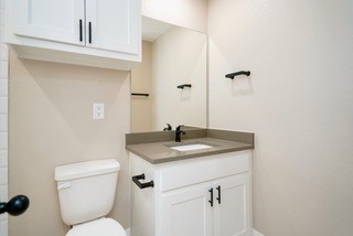 10492 Hammerly Boulevard, Unit 83 Houston, TX 77043 - Photo 16 of 30 a bathroom with a granite countertop sink toilet and mirror