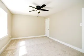 an empty room with window and ceiling fan