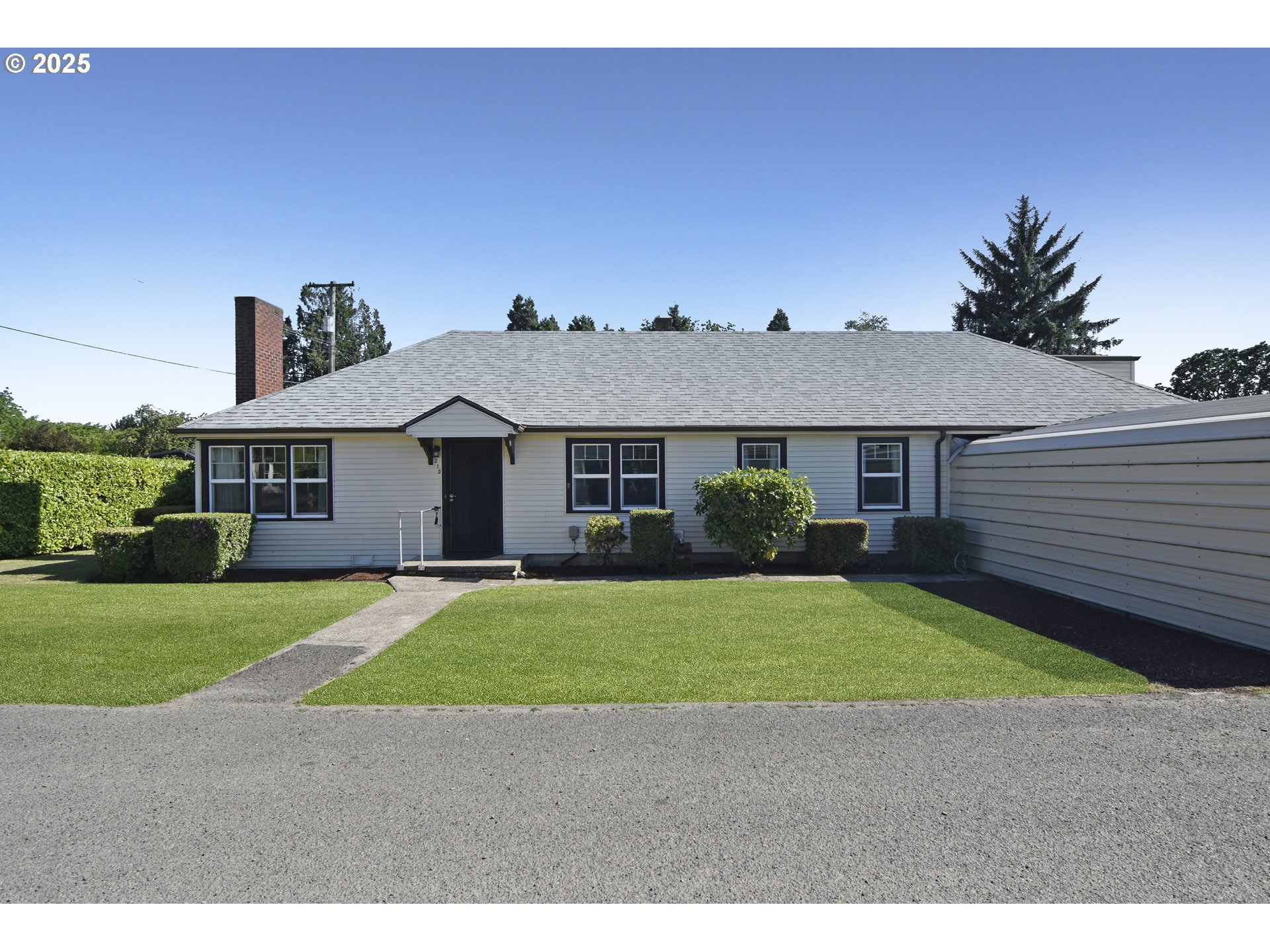 a aerial view of a house next to a yard with big trees