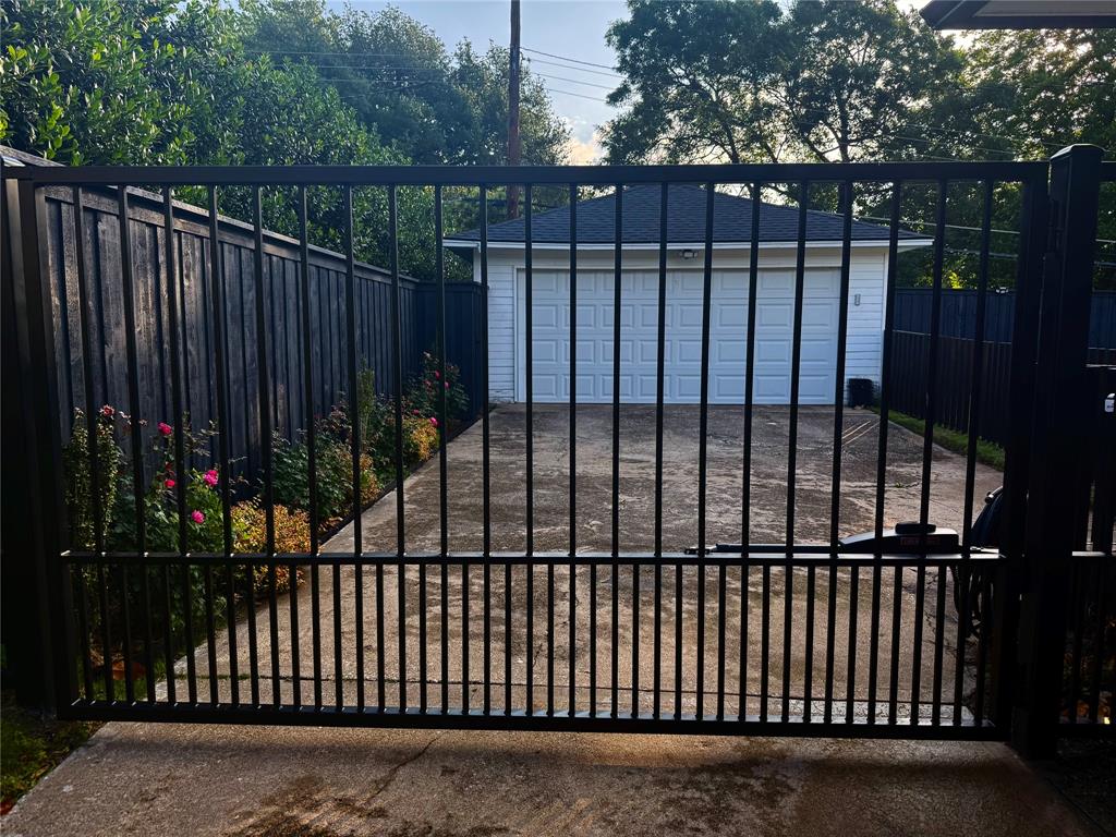 864 Peavy Road Dallas, TX 75218 - Photo 21 of 21 Black metal vehicular gate securing a concrete driveway
