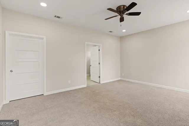 an empty room with a ceiling fan and window