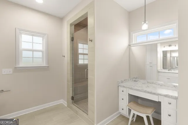 a bathroom with a granite countertop sink a mirror and a shower