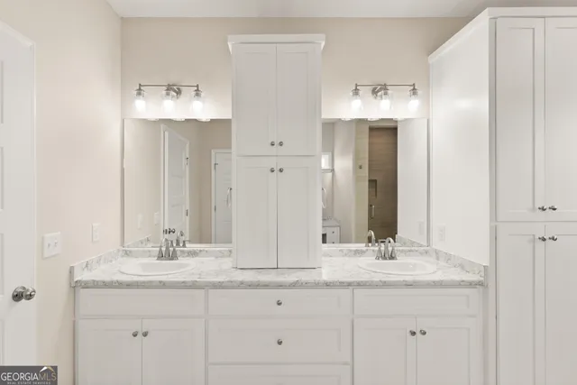 a bathroom with double sink and a mirror