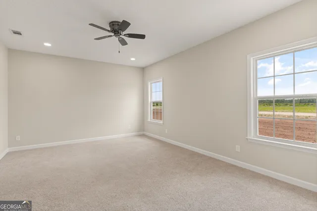 an empty room with window and ceiling fan
