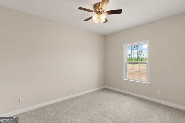 an empty room with a window and a fan