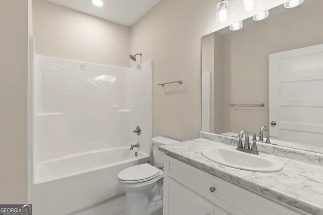 a bathroom with a granite countertop sink a toilet and shower