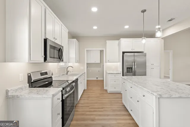 a open kitchen with stainless steel appliances granite countertop a stove a sink and a refrigerator