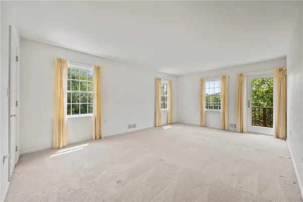 a view of an empty room with a fireplace and a window