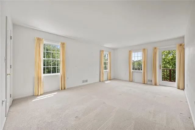 a view of an empty room with a fireplace and a window