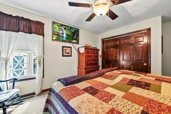 a bedroom with a bed a dresser next to a window