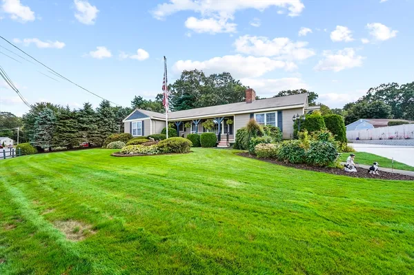 a view of a house with a big yard and potted plants