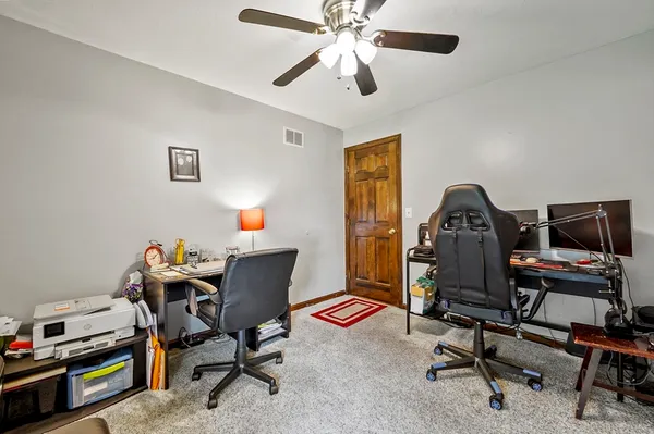 a view of a workspace with furniture and a window