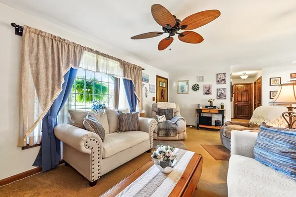 a living room with furniture ceiling fan and a rug