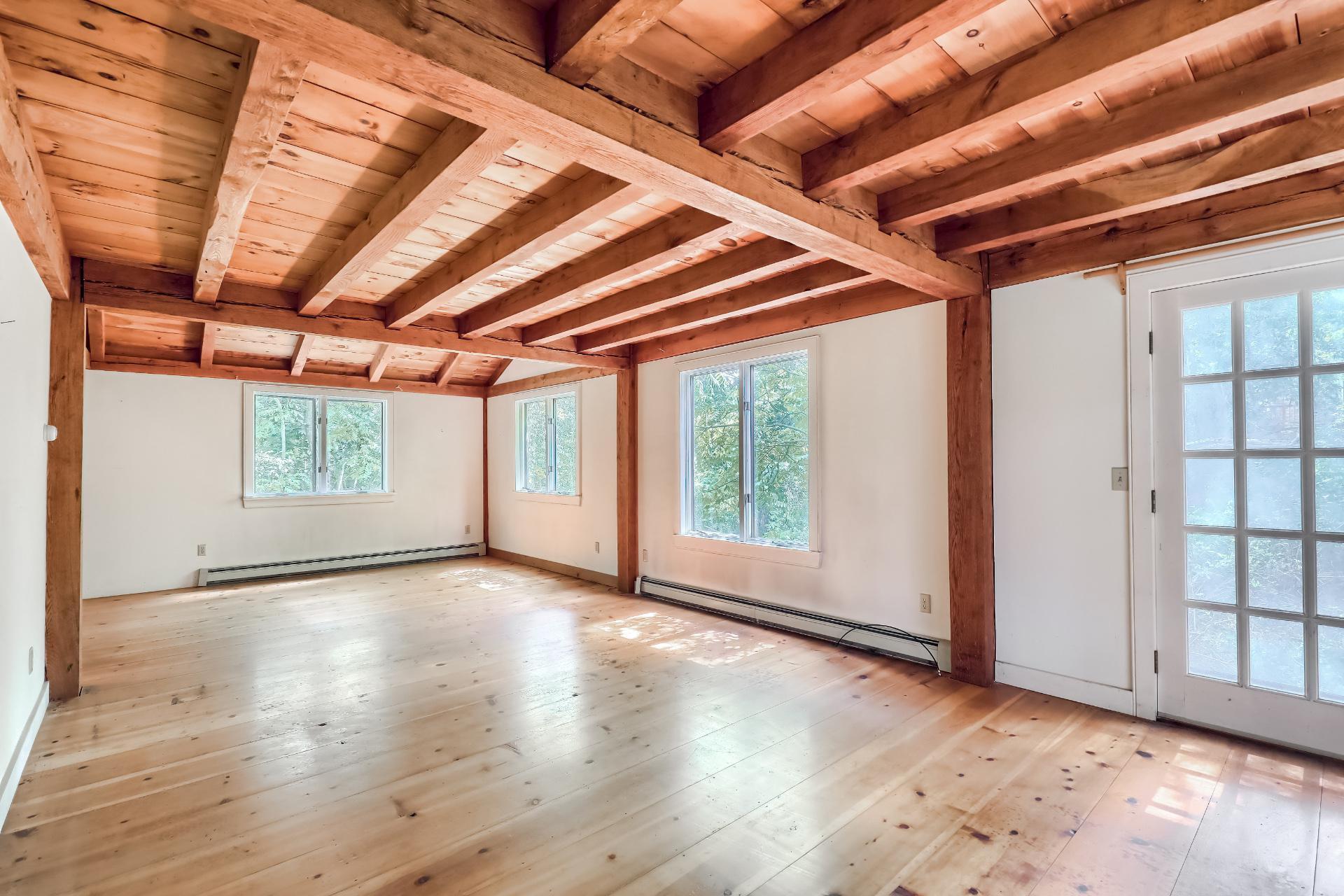309 Great Fields Road Brewster, MA 02631 - Photo 7 of 23 an empty room with wooden floor and windows