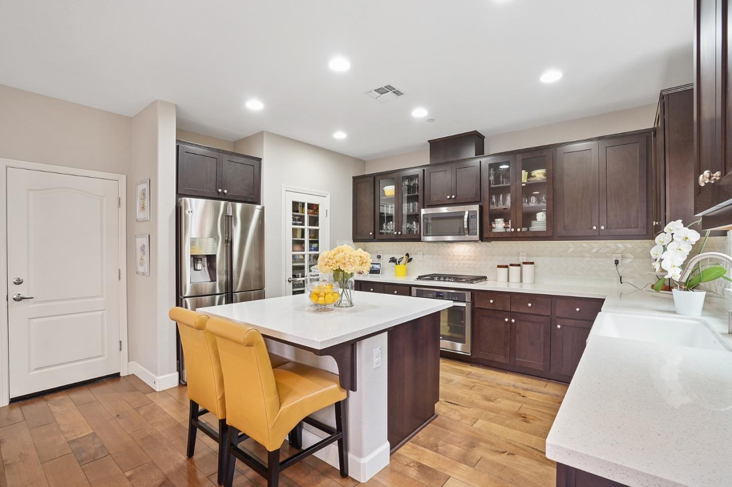 1521 Middle Lane Hayward, CA 94545 - Photo 15 of 34 a kitchen with stainless steel appliances granite countertop a sink a stove a refrigerator a microwave oven with white cabinets and wooden floor