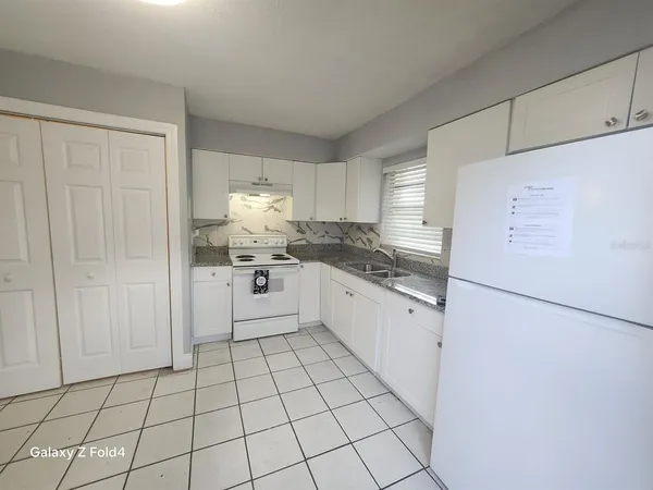 a kitchen with white cabinets and white appliances