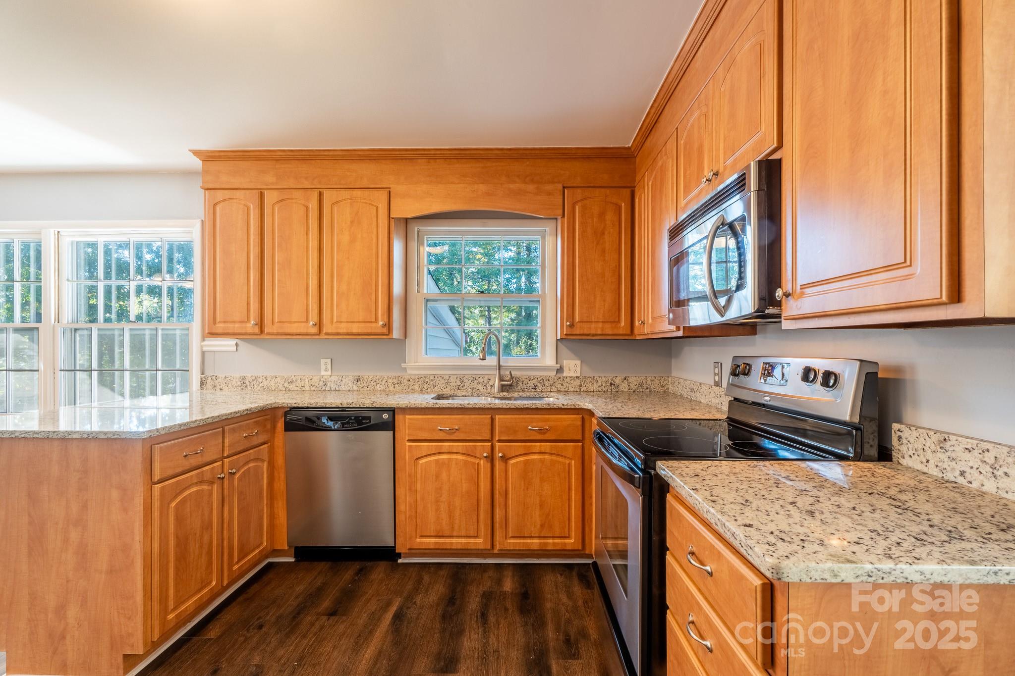 3851 Idlewood Acres Road Hickory, NC 28601 - Photo 11 of 34 a kitchen with stainless steel appliances granite countertop wooden cabinets a sink and dishwasher a stove with wooden floor