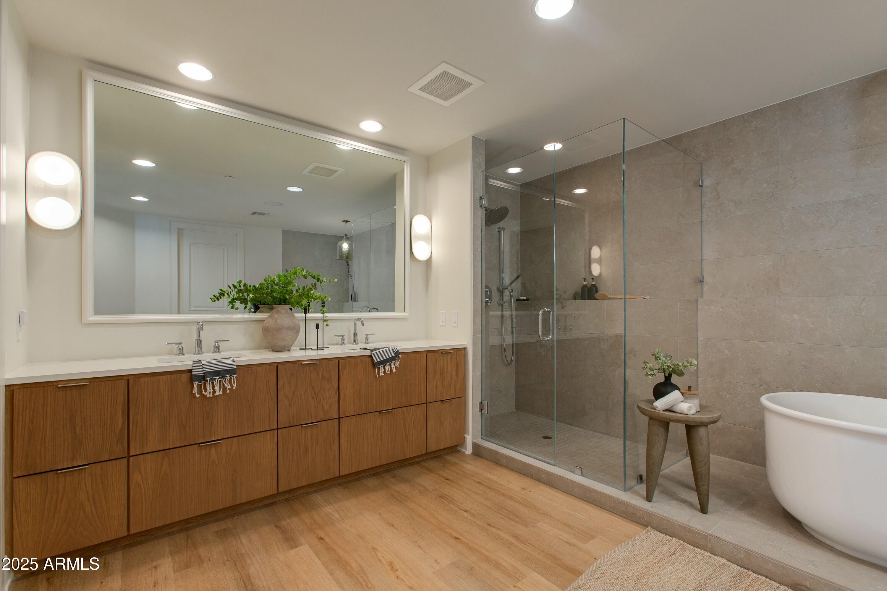 2211 East Camelback Road, Unit 402 Phoenix, AZ 85016 - Photo 12 of 27 a bathroom with a granite countertop sink a toilet a mirror and shower