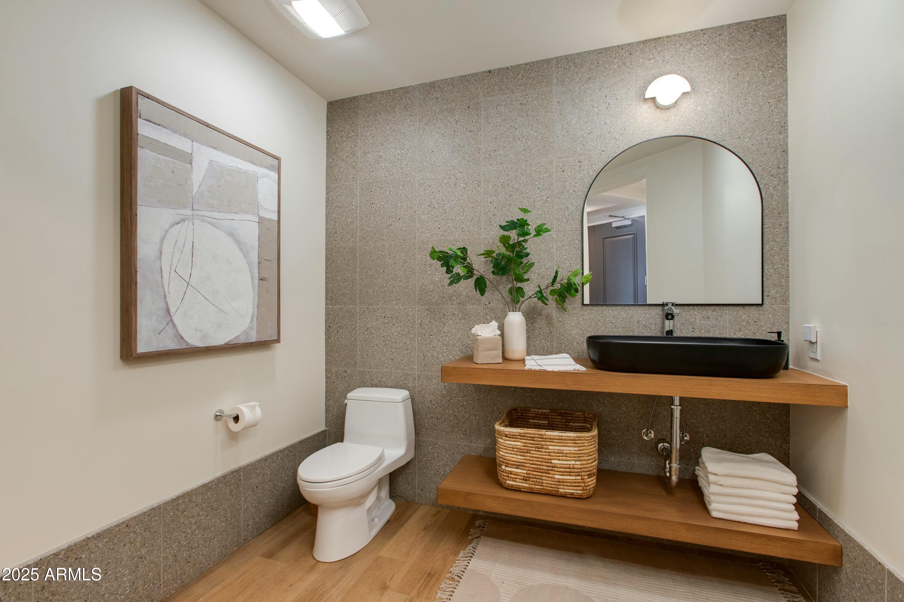 2211 East Camelback Road, Unit 402 Phoenix, AZ 85016 - Photo 16 of 27 a bathroom with a toilet a sink and mirror