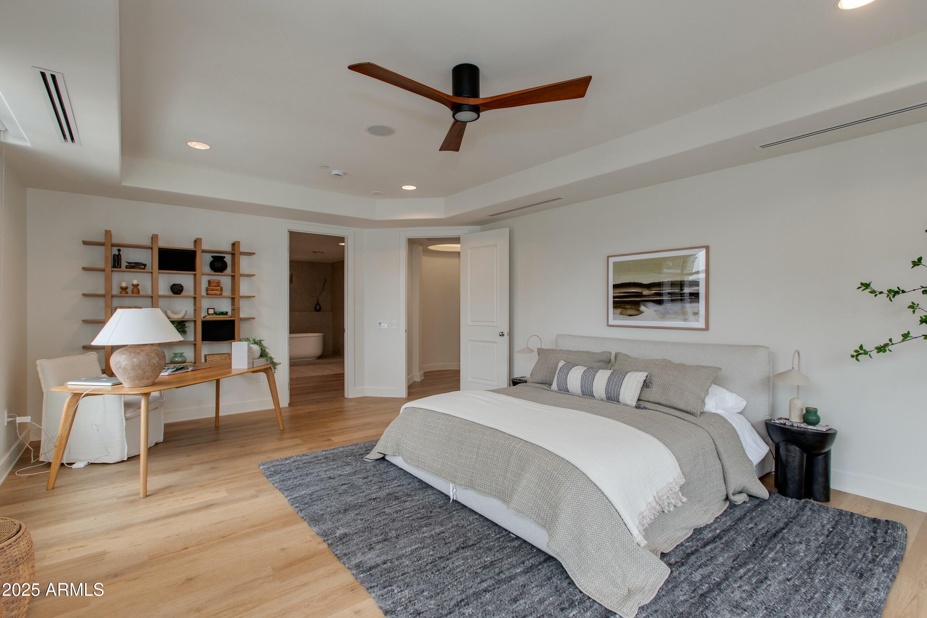 2211 East Camelback Road, Unit 402 Phoenix, AZ 85016 - Photo 10 of 27 a bedroom with a large bed and a chandelier